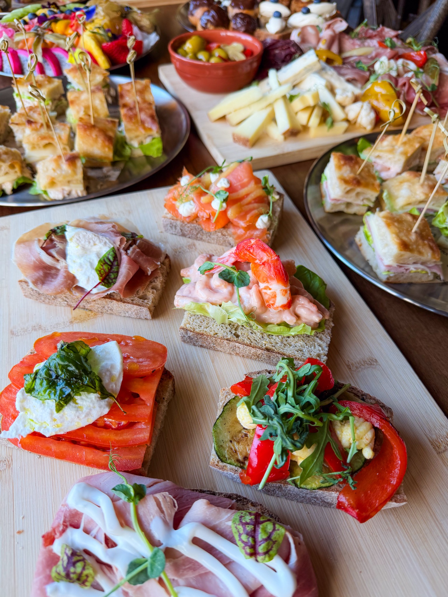 Otto open sandwiches with focaccia, cheese and charcuterie behind
