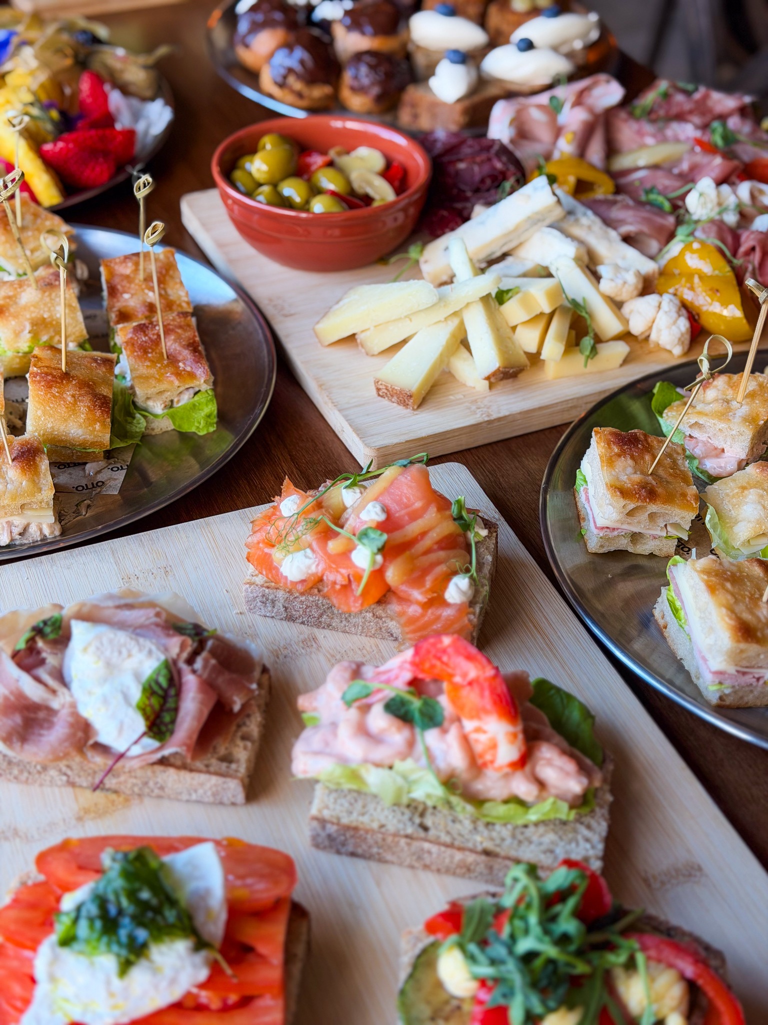 Open sandwiches alongside focaccia and a cheese sharing board