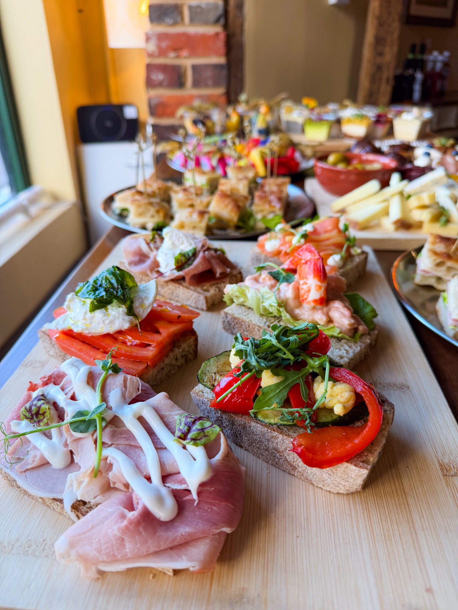 A selection of Otto open sandwiches arranged on a wooden board